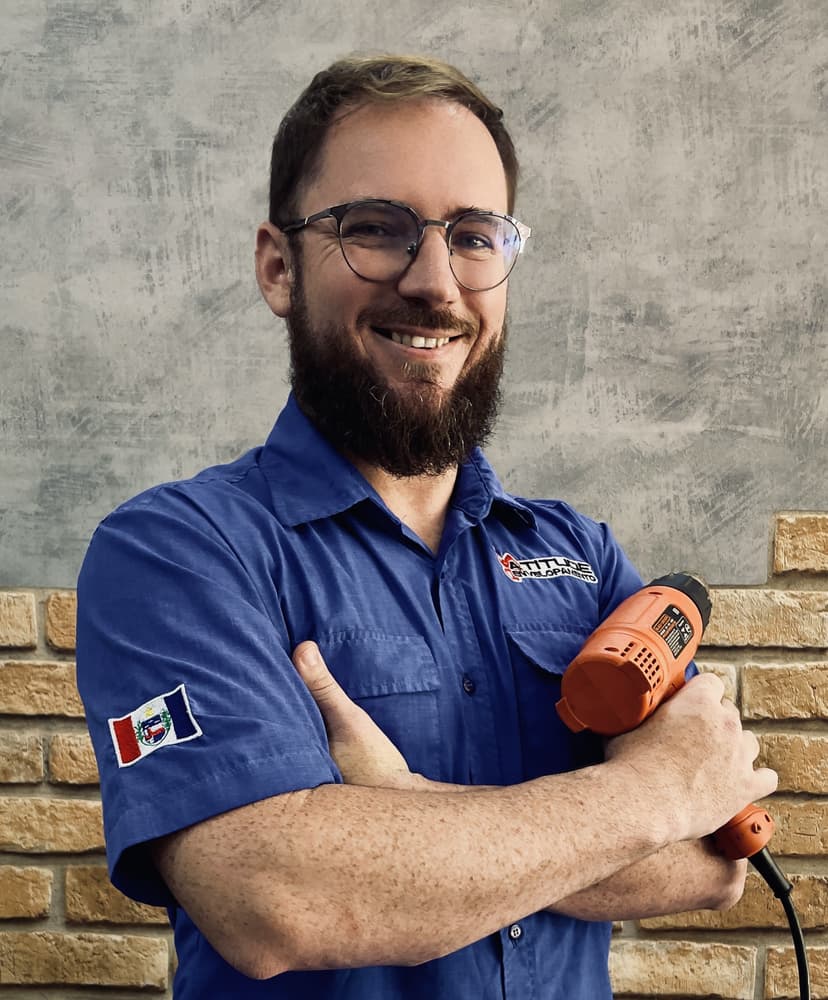A professional applying a vinyl wrap to a car part.